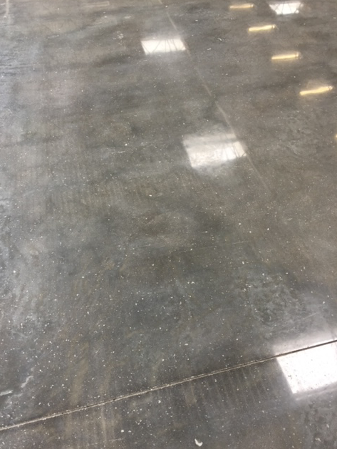 A close up of a shiny concrete floor in a warehouse.