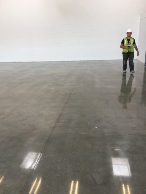 A man in a hard hat is standing in an empty room