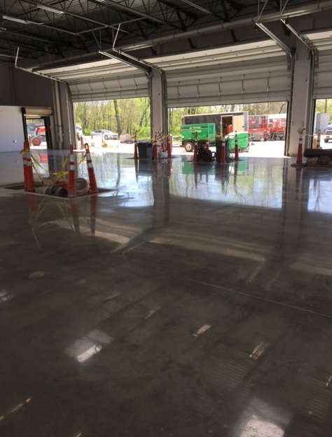 A large garage with a green truck parked in it