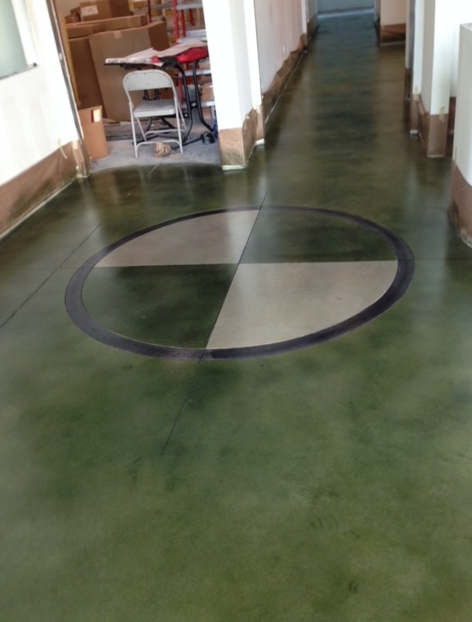 A hallway with a green floor and a circle in the middle