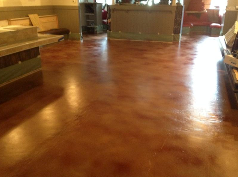 A large room with a wooden floor and a counter in the background.