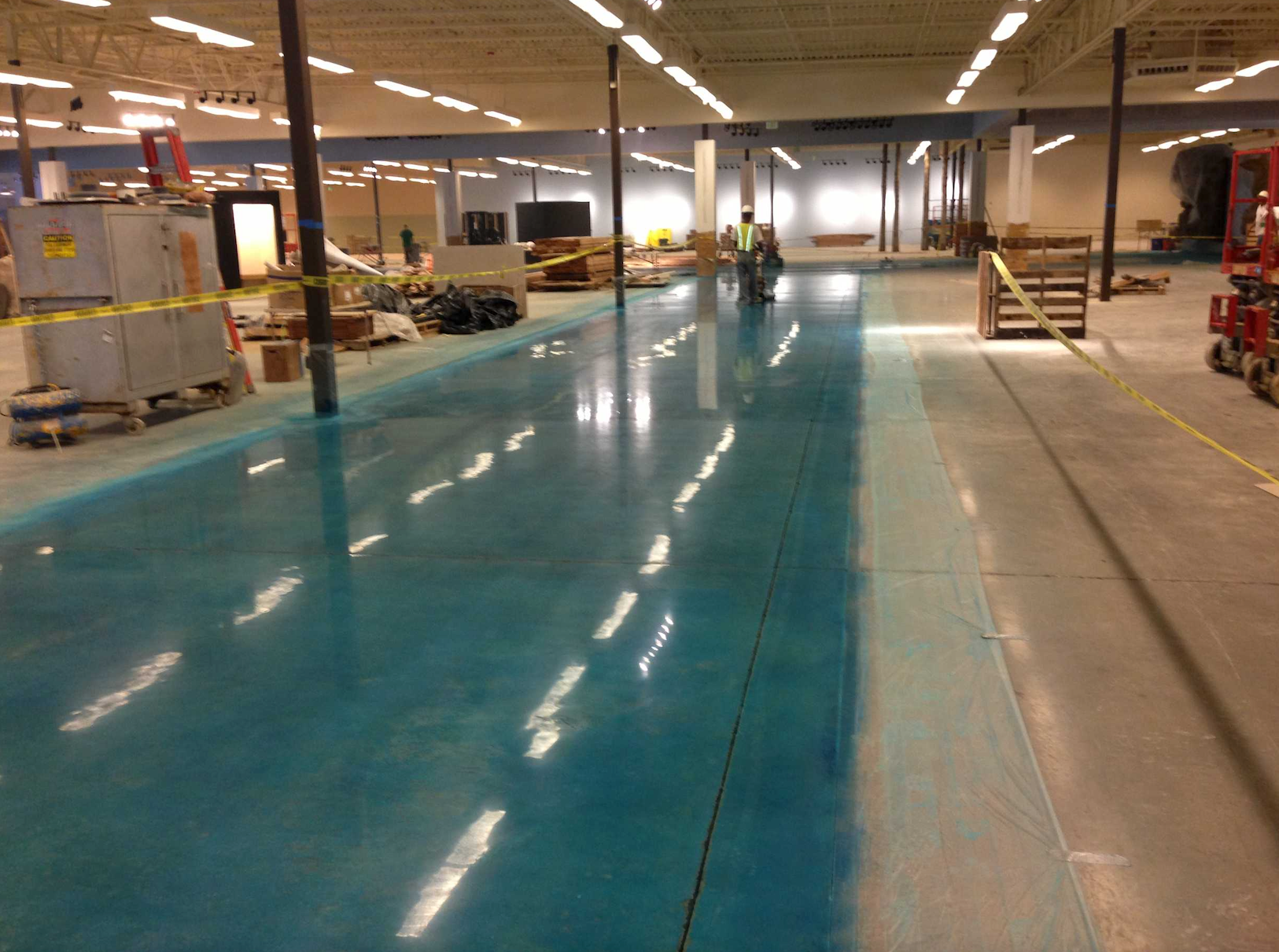 A large warehouse with a blue colored floor