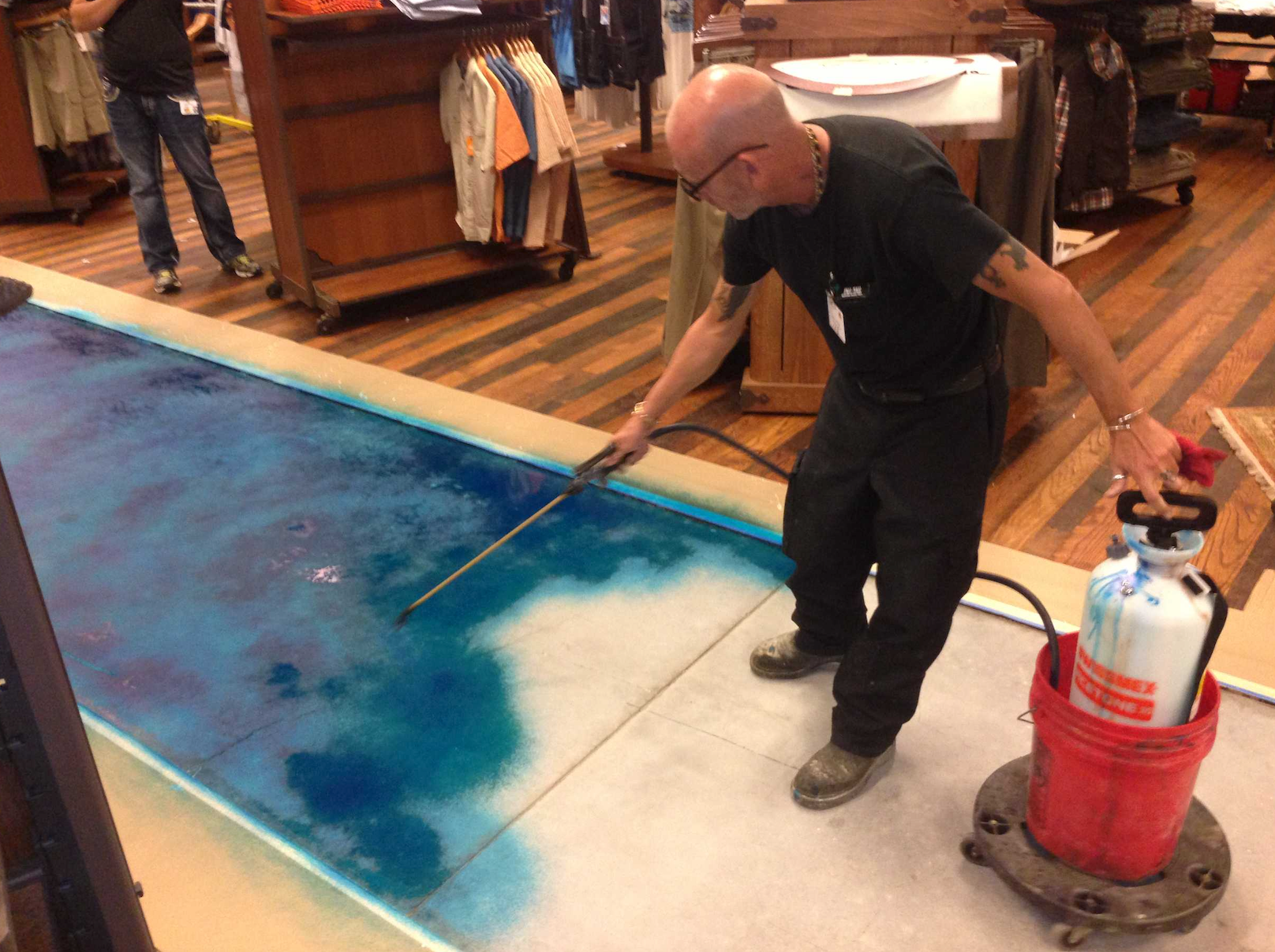 A man is cleaning the floor of a store with a vacuum cleaner.