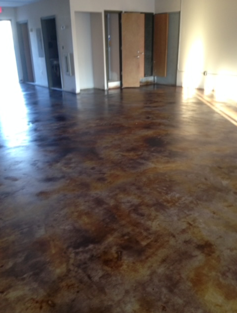 An empty room with a stained concrete floor