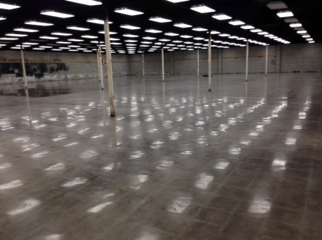 A large empty warehouse with lots of lights on the ceiling