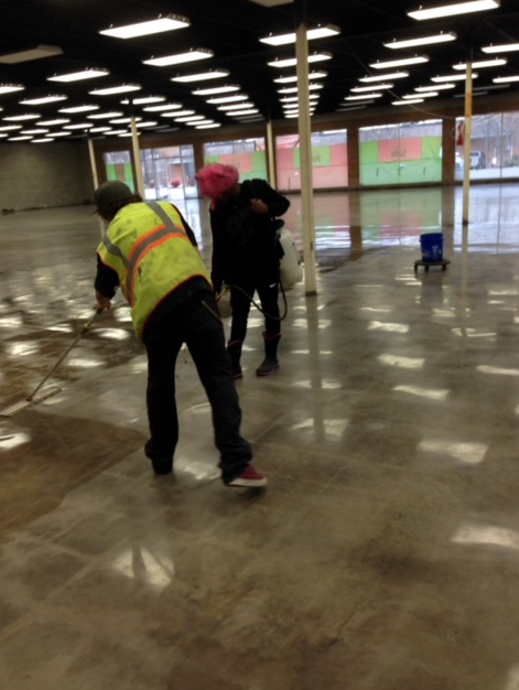 A group of construction workers are working on a concrete floor