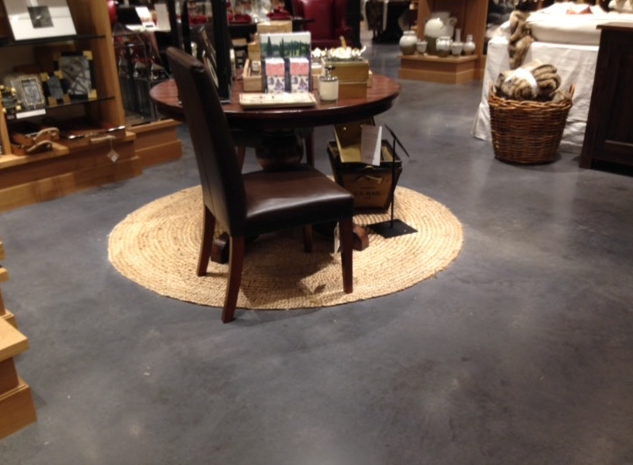 A table and chairs in a store with candles on it