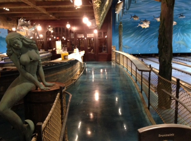 A bowling alley with a statue of a mermaid