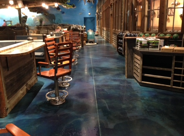 A restaurant with a blue floor and wooden chairs
