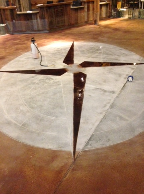 There is a compass on the floor in the shape of a cross.