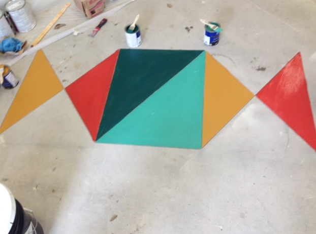 Colorful triangles are painted on a concrete floor