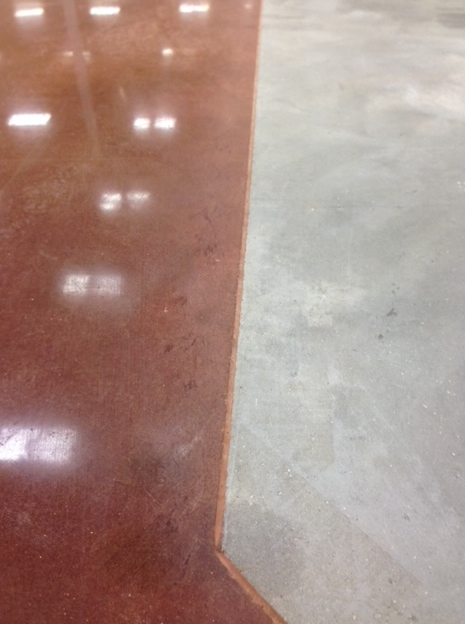 A close up of a concrete floor with a red border and a gray border.