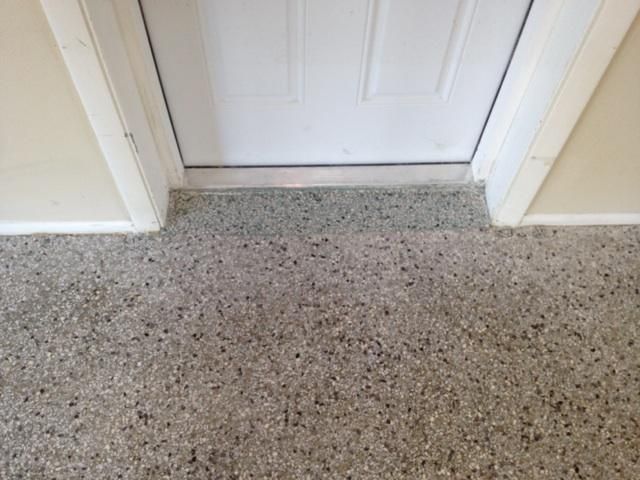 A doorway with a carpeted floor and a white door.