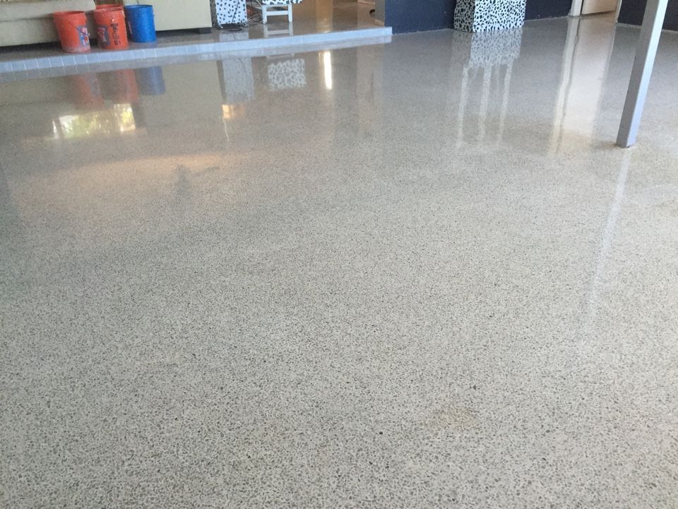 A shiny concrete floor with buckets in the background