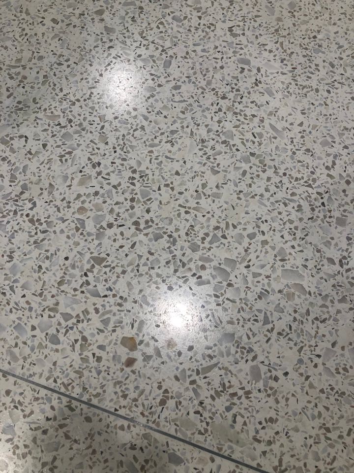 A close up of a white terrazzo floor with a lot of small stones on it.