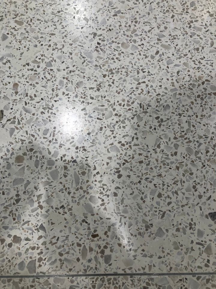 A close up of a concrete floor with a lot of small stones on it.