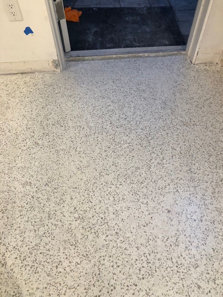 A white floor with a door in the background