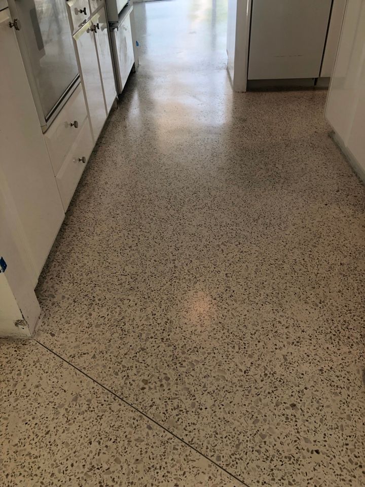 A kitchen with a white tile floor and white cabinets.
