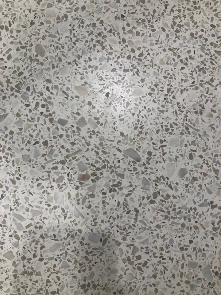 A close up of a concrete floor with a lot of small rocks on it.