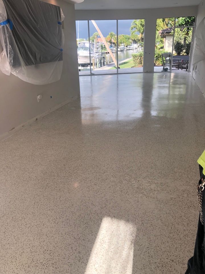 A large empty room with a concrete floor and a large window.