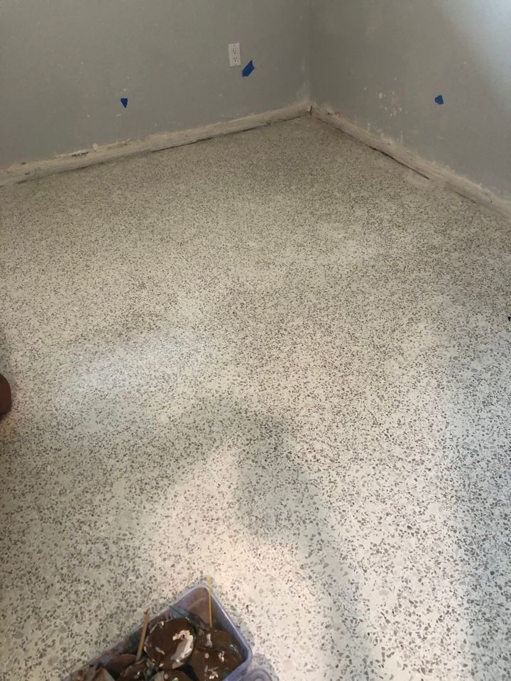 A room with a white carpeted floor and a box of bricks on the floor.