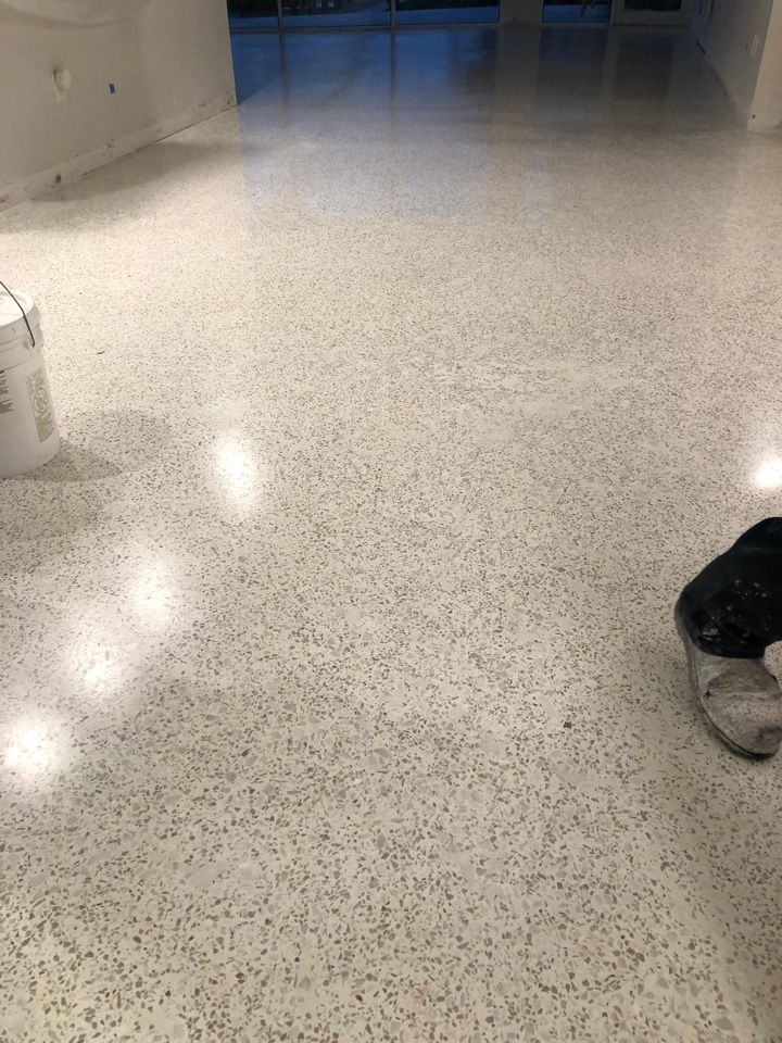 A person is standing on a white terrazzo floor.