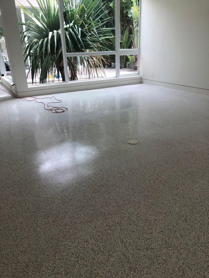 A room with a shiny floor and a large window.