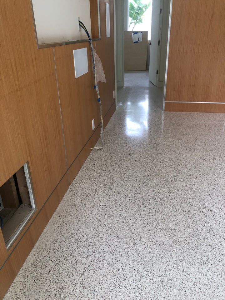 A hallway with a white floor and wooden walls