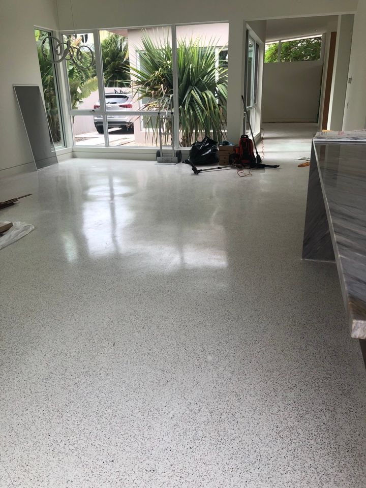 A living room with a white floor and a lot of windows.