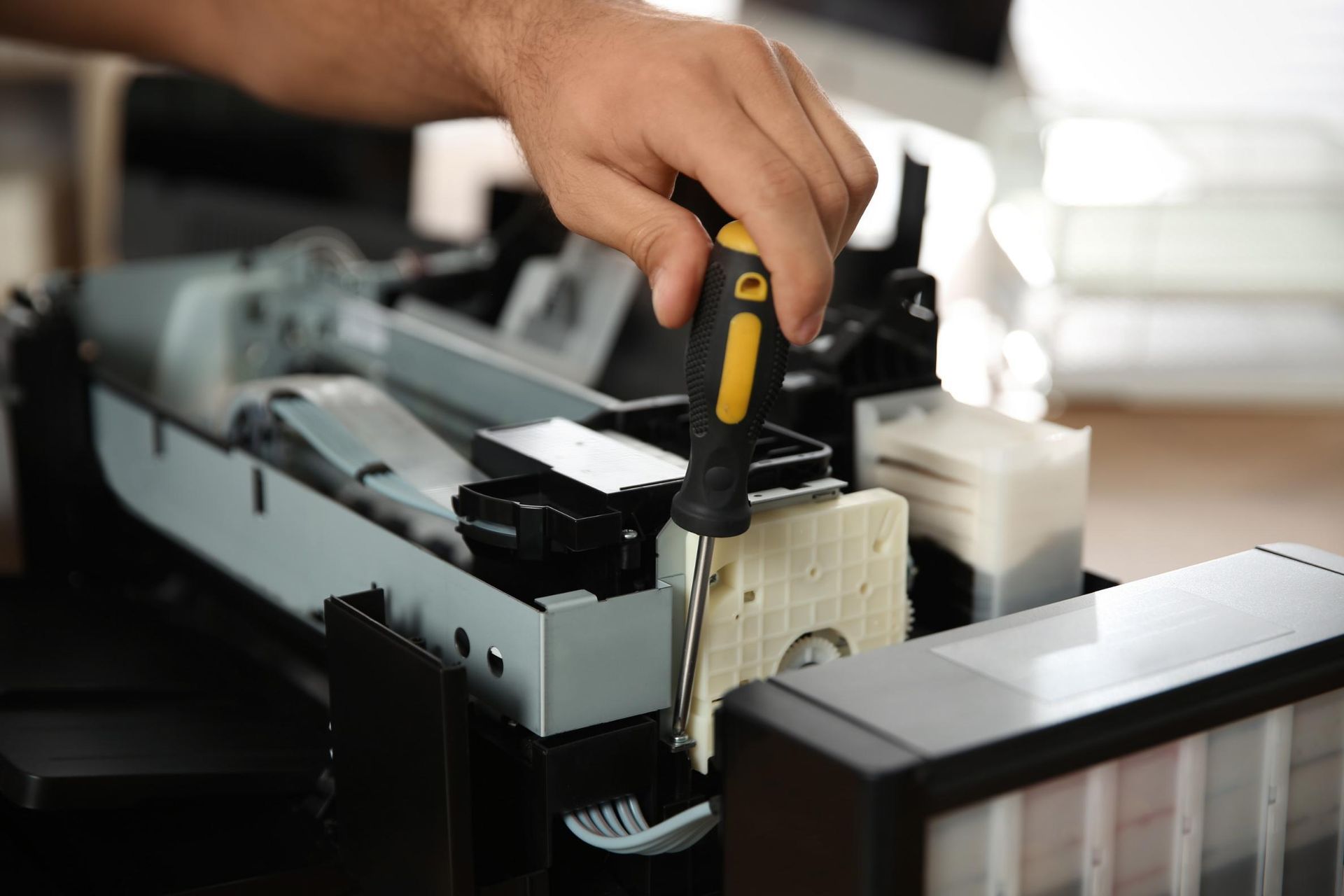 A Man Is Fixing a Printer with A Screwdriver — Ink n' Toner Forster in Old Bar, NSW