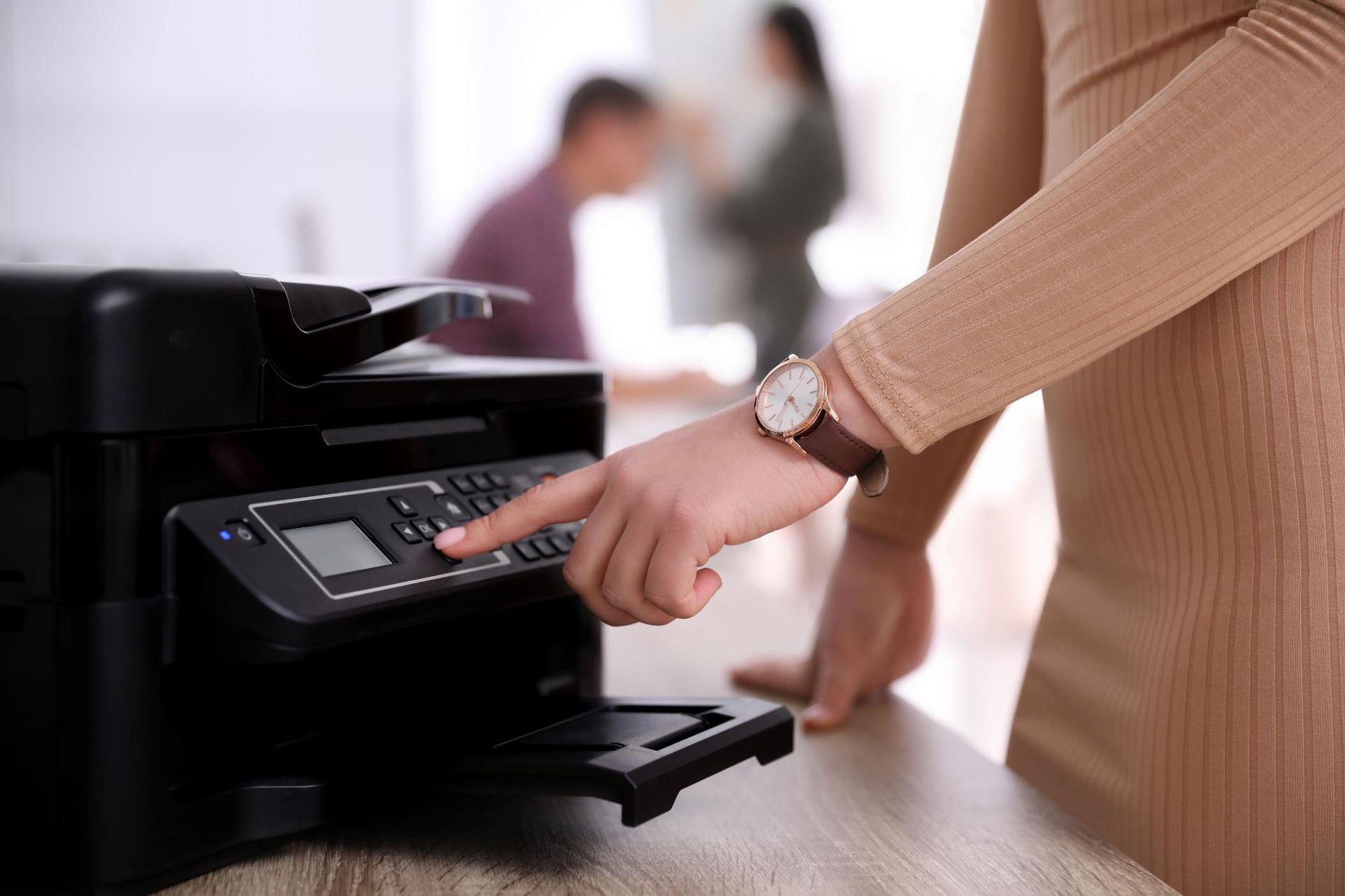 A Woman Is Using a Printer in An Office — Ink n' Toner Forster in Taree, NSW