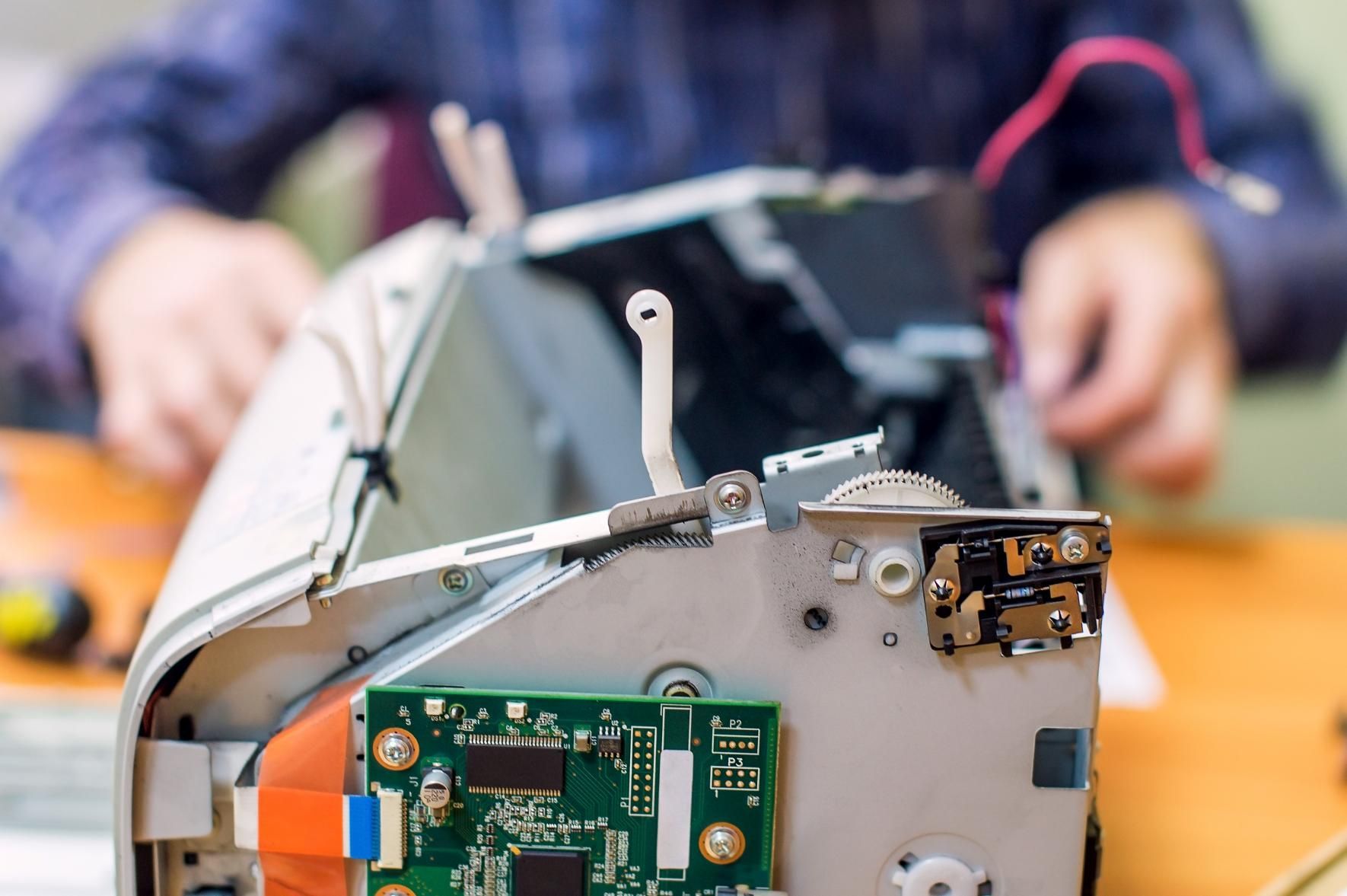 A Person Is Fixing a Printer on A Table — Ink n' Toner Forster in Harrington, NSW