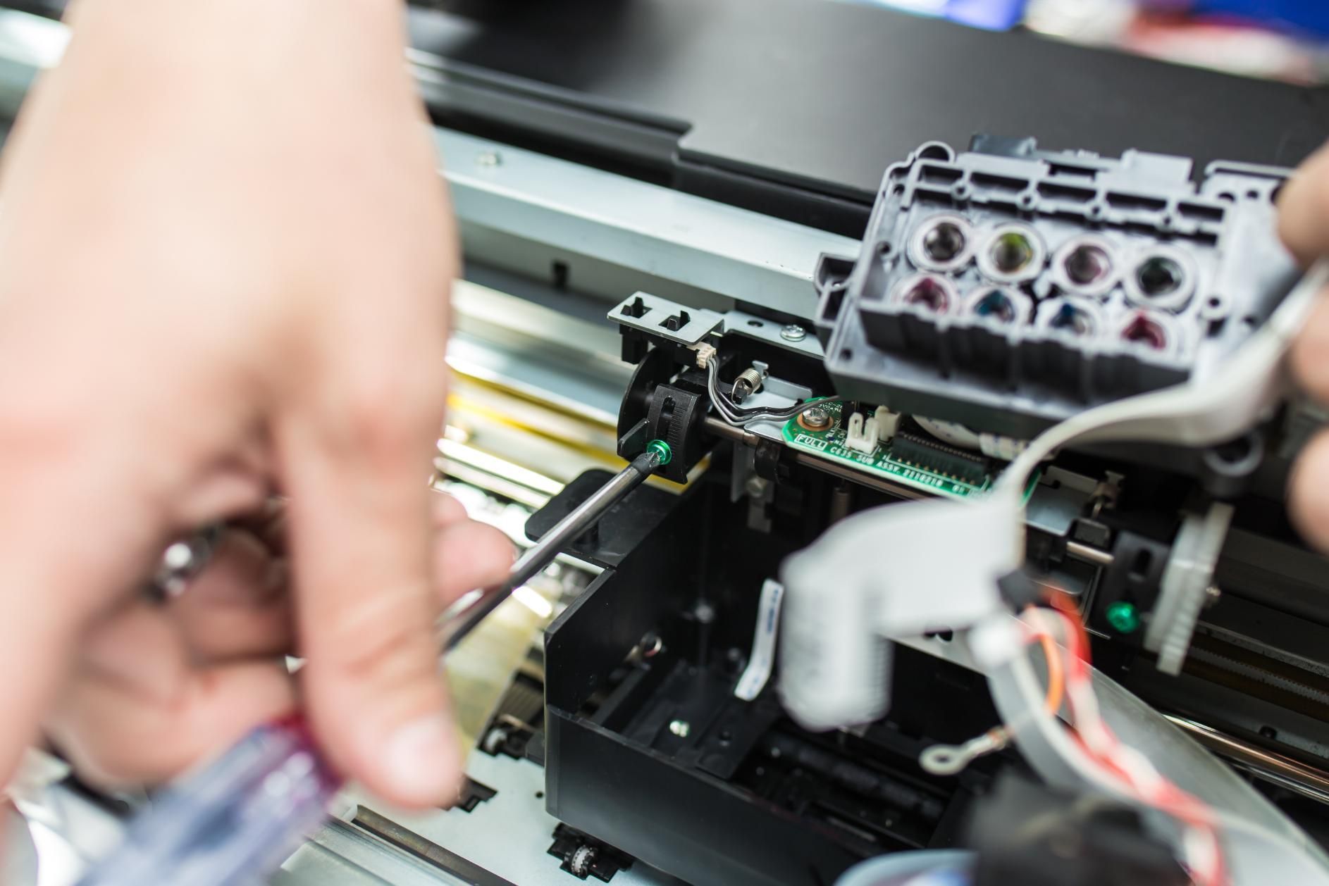 A Person Is Fixing a Printer with A Screwdriver — Ink n' Toner Forster in Harrington, NSW