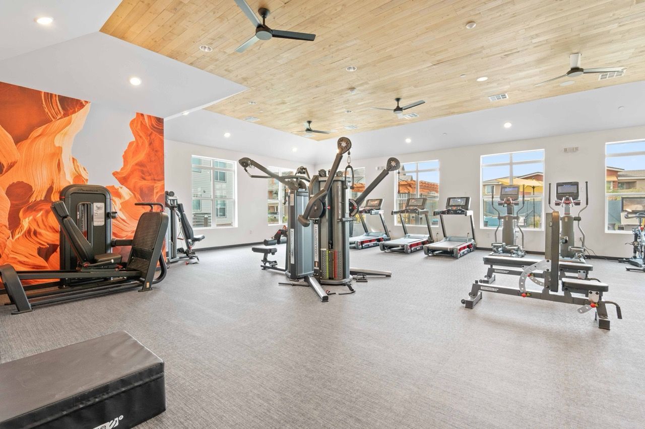 Bright community gym with cardio machines and weight equipment.