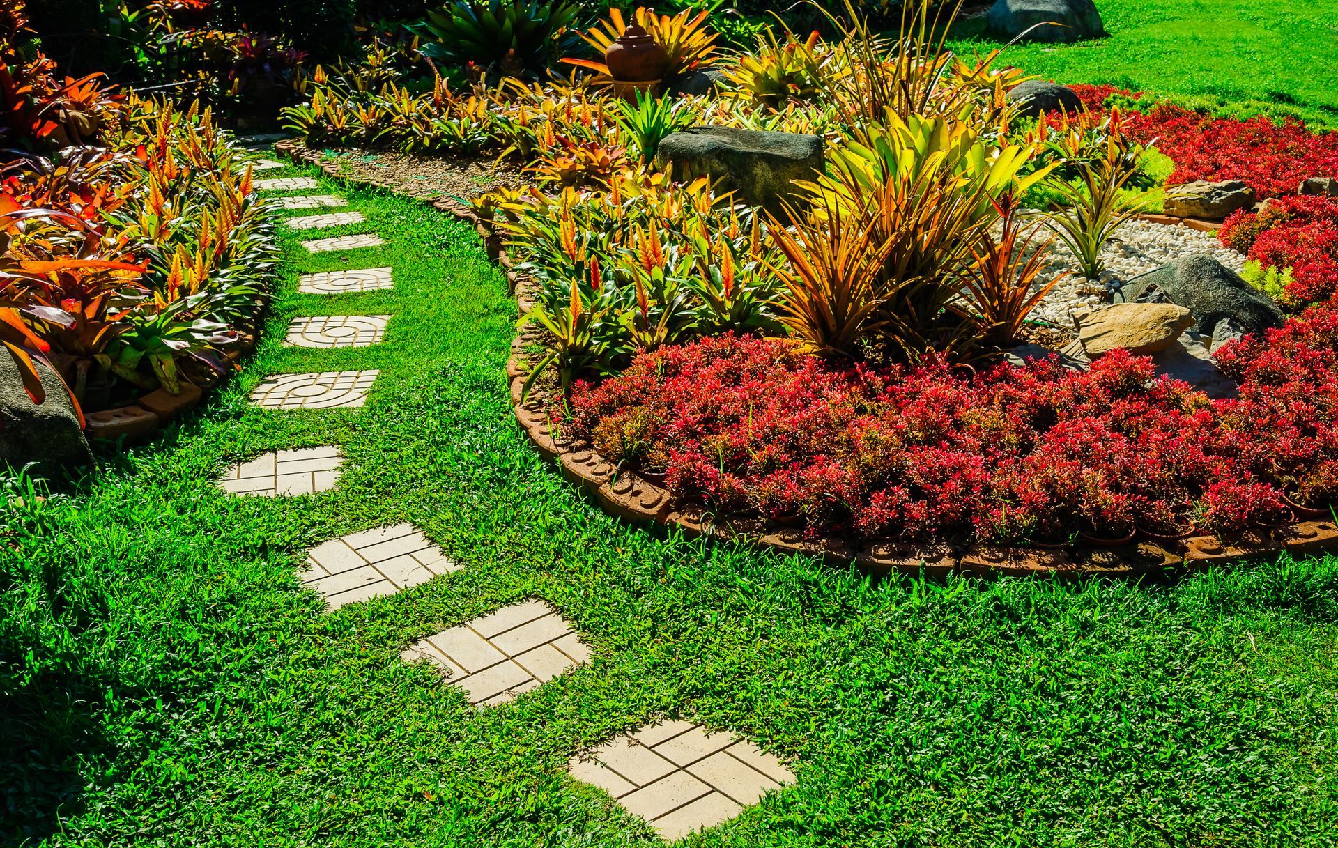 Garden landscape design with pathway intersecting bright green lawns and shrubs
