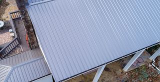 An aerial view of a house with a metal roof and a deck.