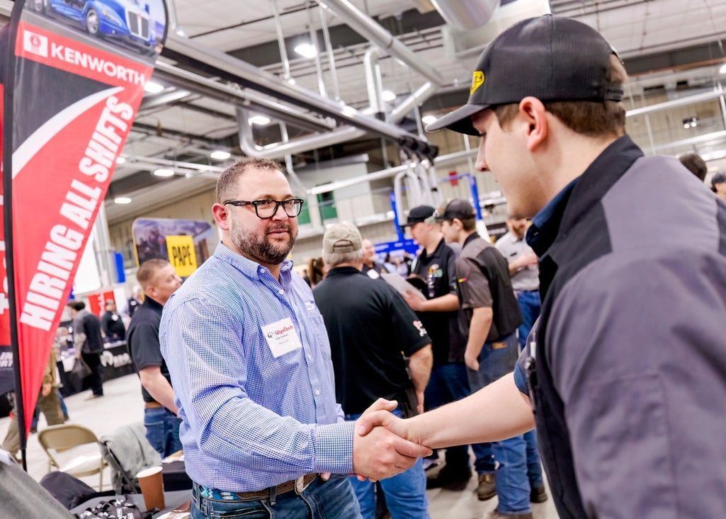 A man is shaking hands with another man at a WyoTech Career Fair.