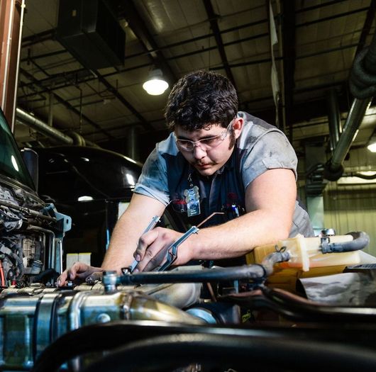 A WyoTech advanced diesel student is working on an engine