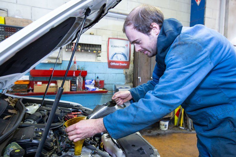 A Man Refilling The Oil Of The Car - Adelaide, SA - Silver’s Auto Centre