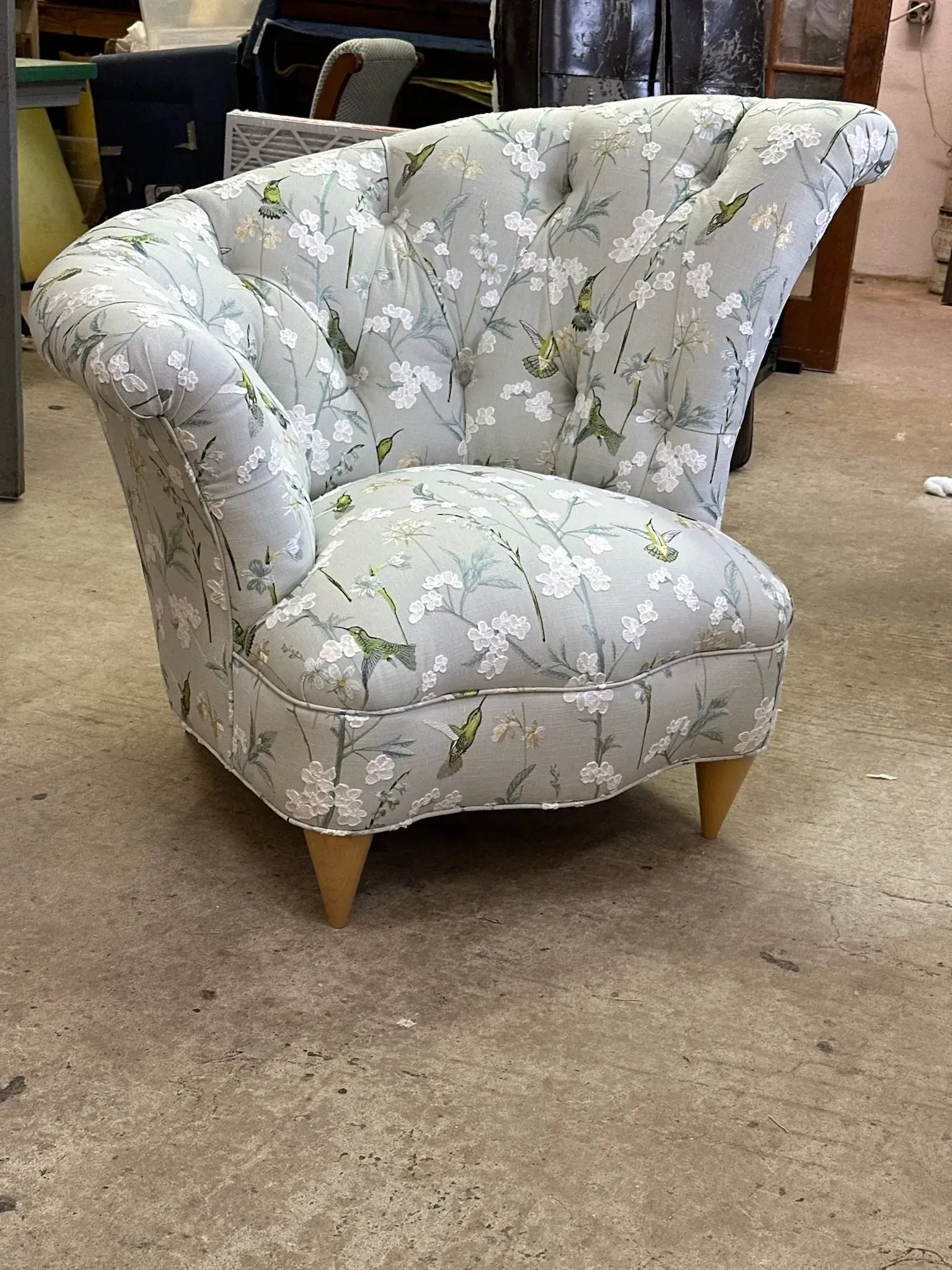 Reupholstered chair with soft floral fabric and a refreshed, elegant curved design.