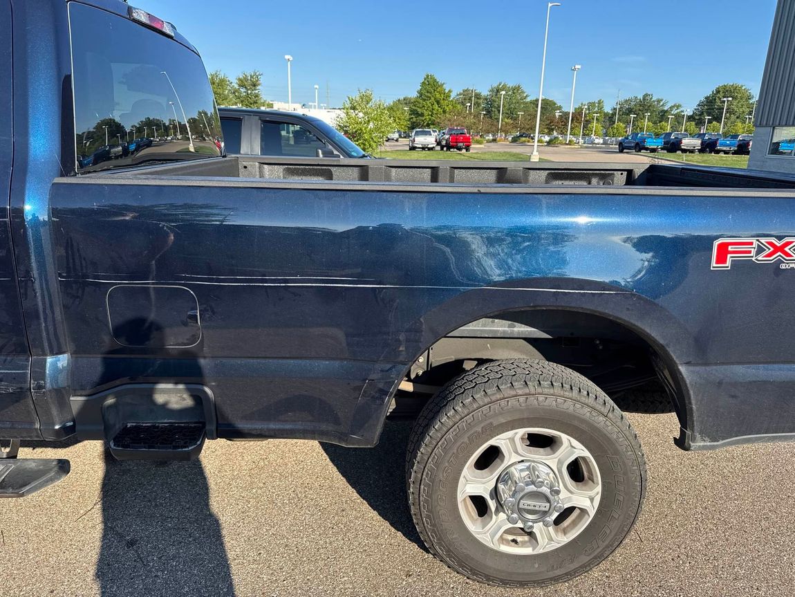 Blue Ford truck with an FX4 logo parked outside on a sunny day.