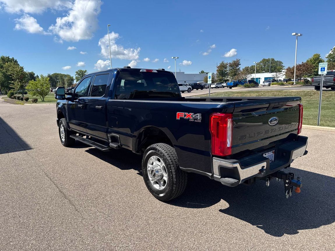 Dark blue Ford Super Duty truck parked outdoors on a sunny day.