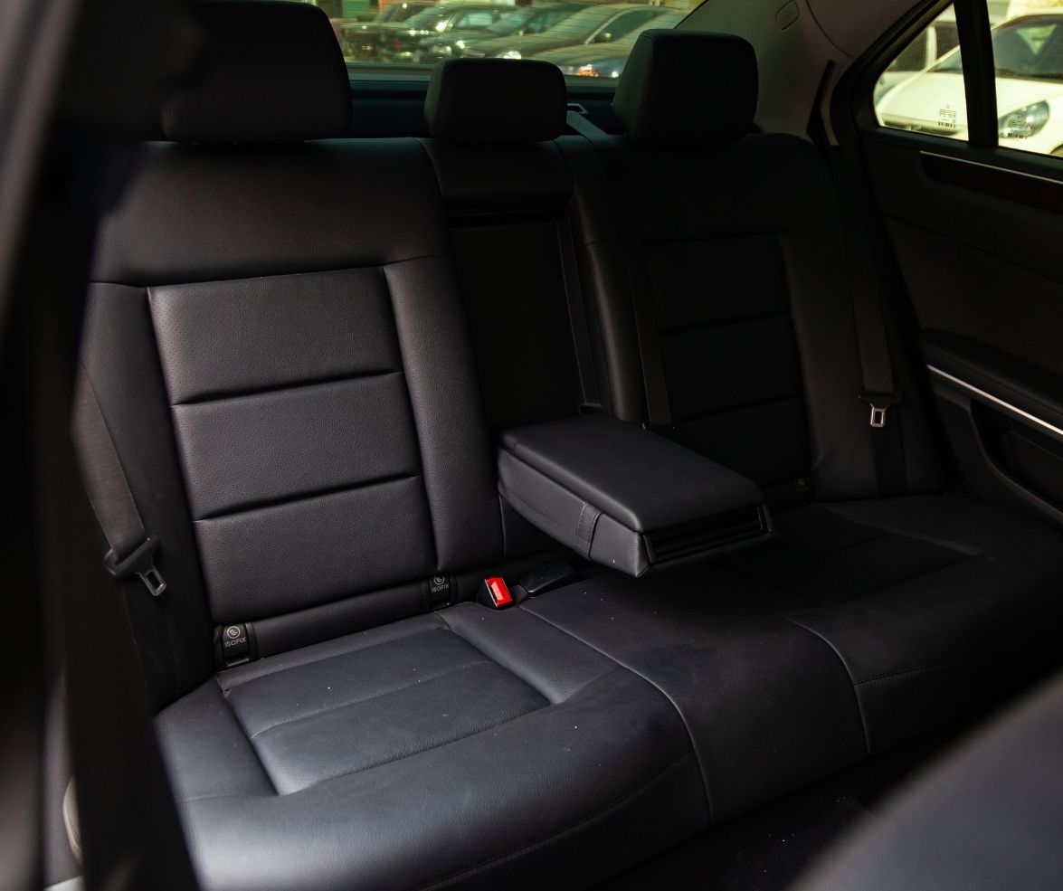 Black leather car backseat with a fold-down armrest