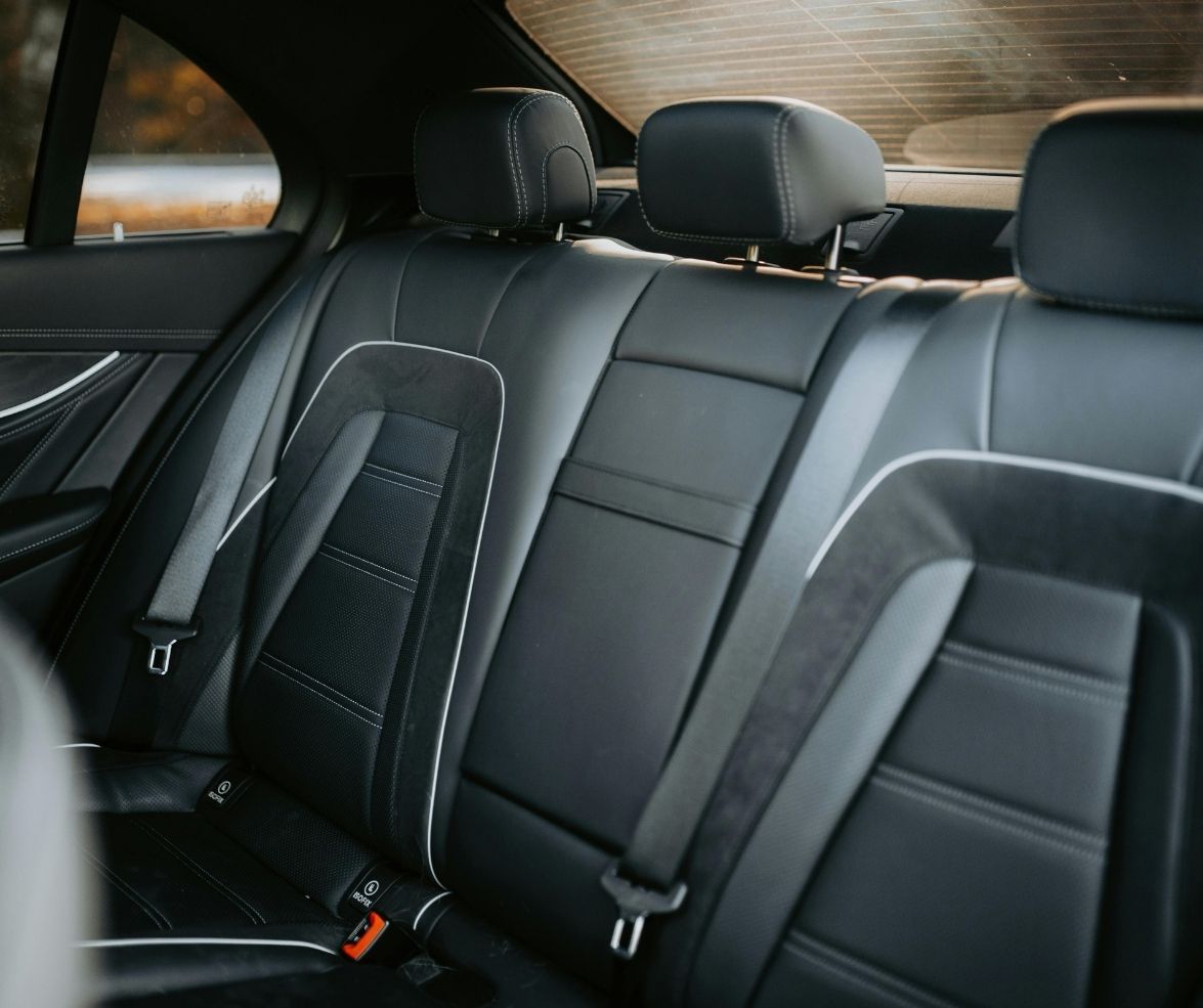 Rear view of a car's interior showing sleek black leather seats with headrests