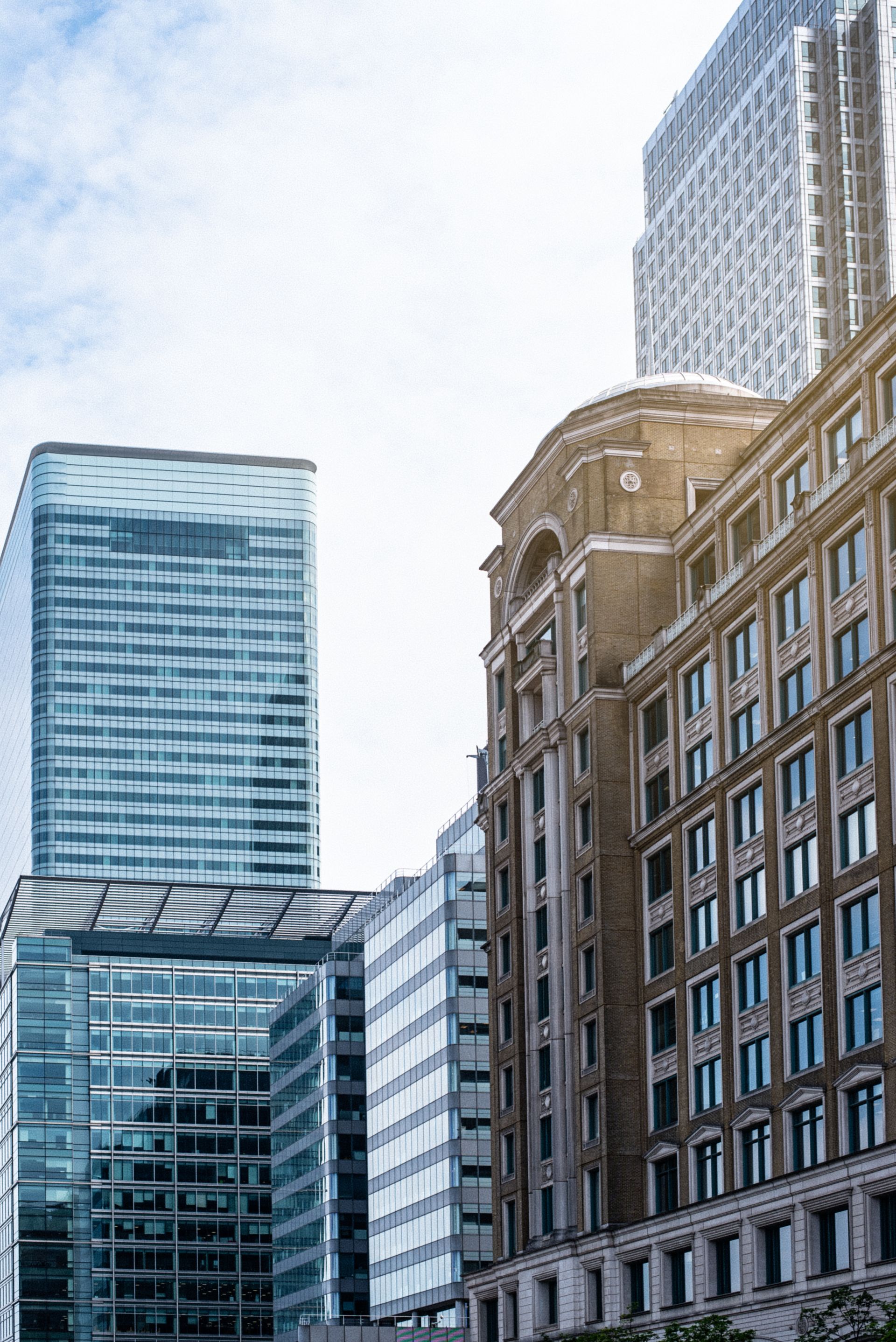 Downtown cityscape with modern and older buildings under a cloudy sky.