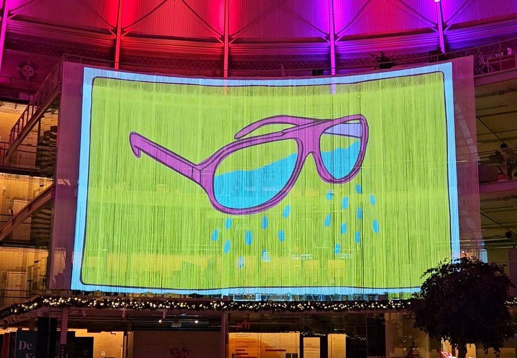 Projectie van een roze zonnebril met water op een groene achtergrond.