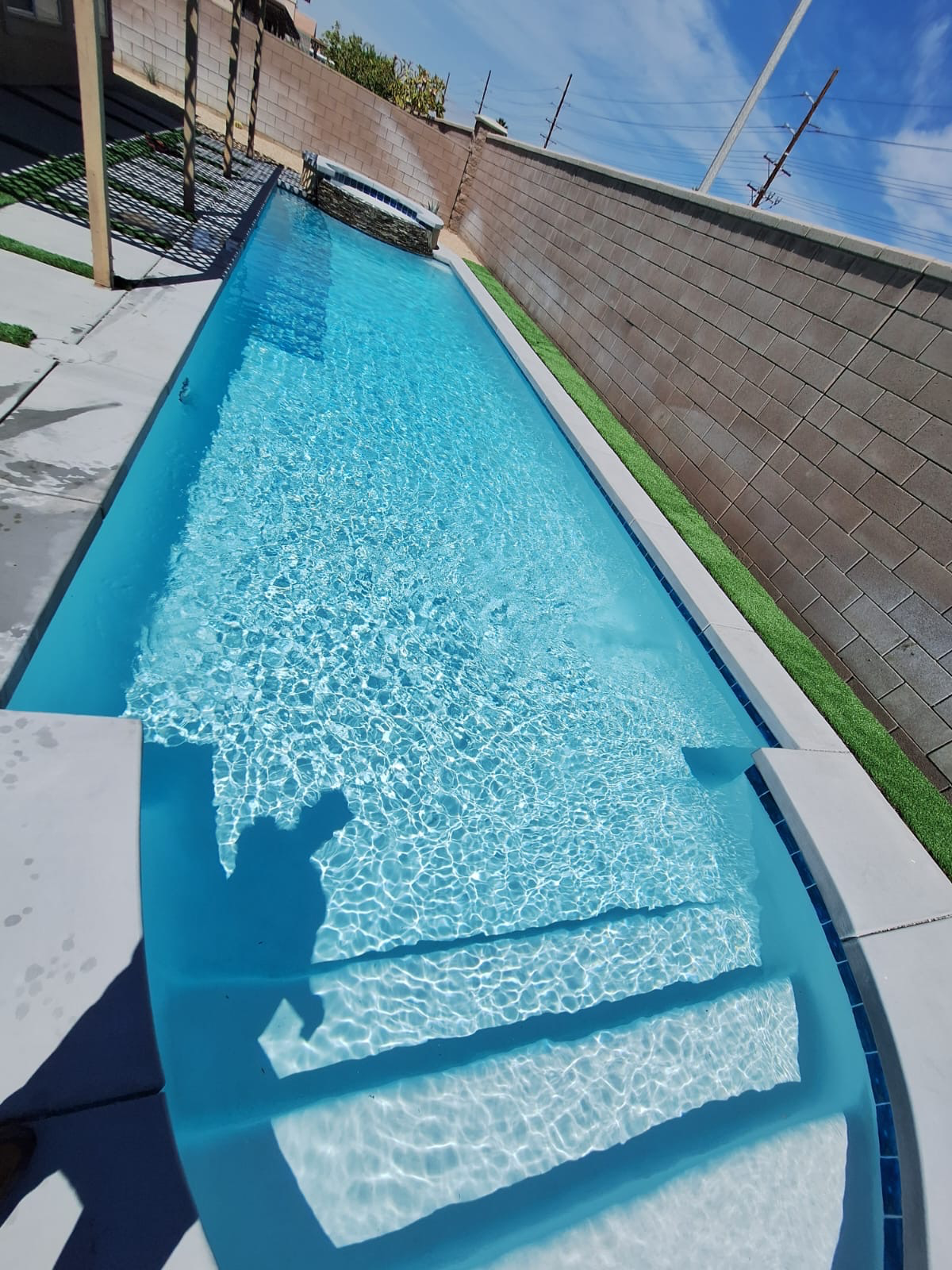 A very long swimming pool with stairs leading to it