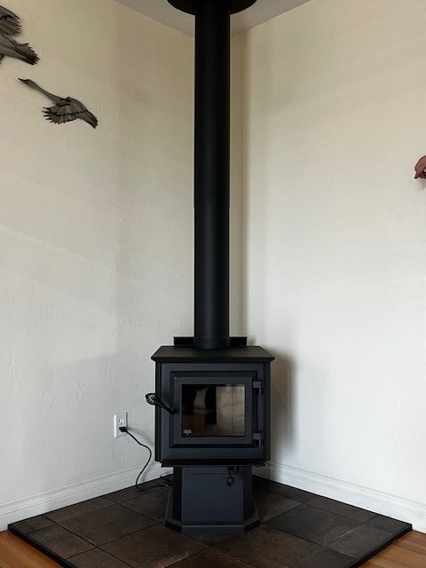 A black wood stove is in the corner of a room