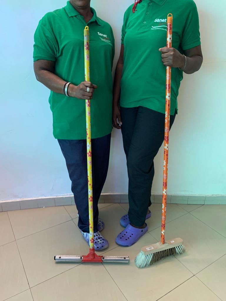 Deux femmes debout l'une à côté de l'autre tenant une serpillère et un balai