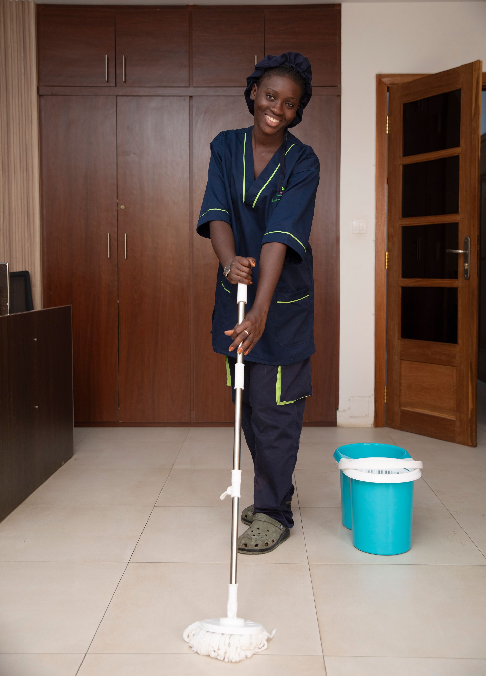 Un homme nettoie le sol d'un bureau avec une serpillère.